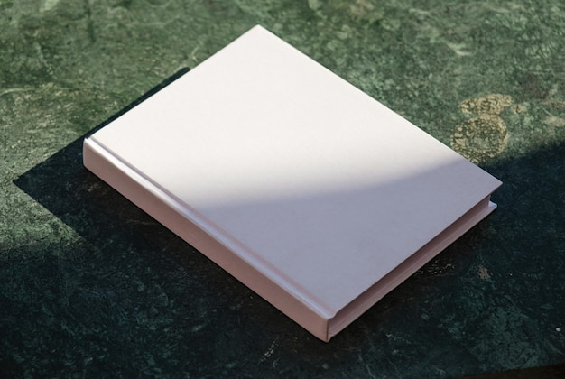 Leerbuch-Mockup auf grünem Marmor-Stein-Coffee-Tisch-Schatten-Overlay