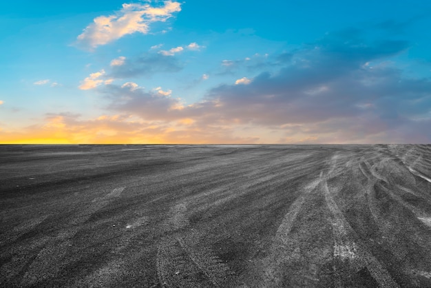 Leere Asphaltstraße und Naturlandschaft in der untergehenden Sonne