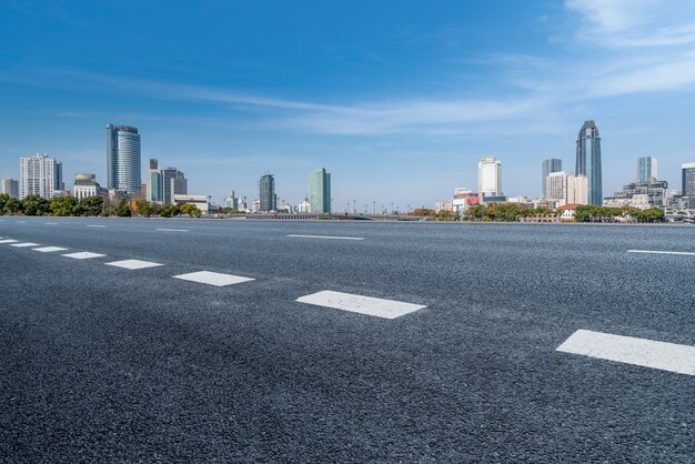 Leere Asphaltstraße und Skyline der Stadt und Gebäudelandschaft, China.