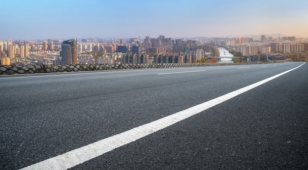 Leere Asphaltstraße und Skyline der Stadt und Gebäudelandschaft, China.