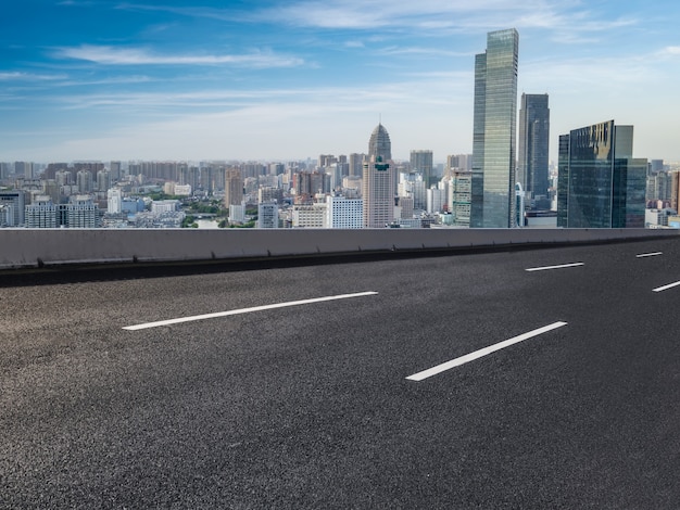 Leere Asphaltstraße und Skyline der Stadt und Gebäudelandschaft, China.