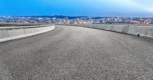 Leere Asphaltstraße und Skyline der Stadt und Gebäudelandschaft, China.