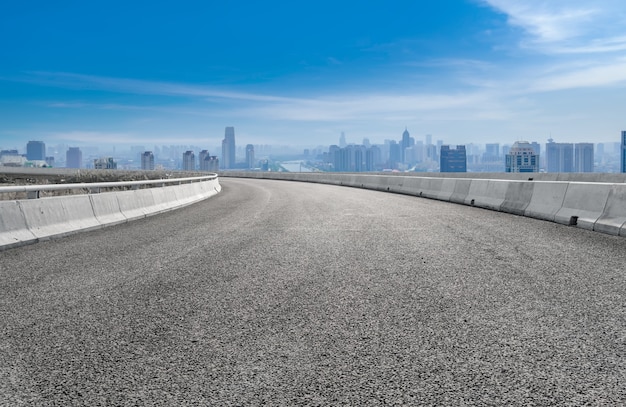 Leere Asphaltstraße und Skyline der Stadt und Gebäudelandschaft, China.