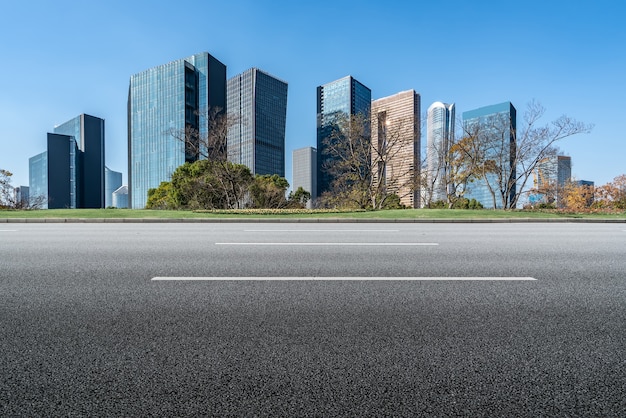 Leere Asphaltstraße und Skyline der Stadt und Gebäudelandschaft, China.