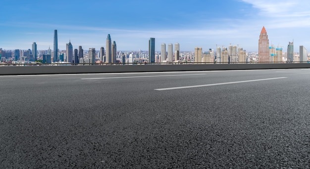 Leere Asphaltstraße und Skyline der Stadt und Gebäudelandschaft, China.