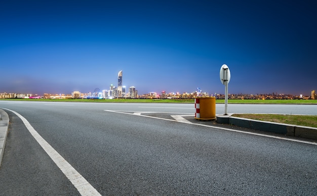 Leere Asphaltstraße und Skyline der Stadt und Gebäudelandschaft, China.