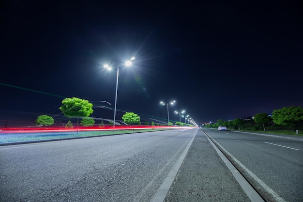 Leere Asphaltstraße und Straßenlaternen in der Nacht