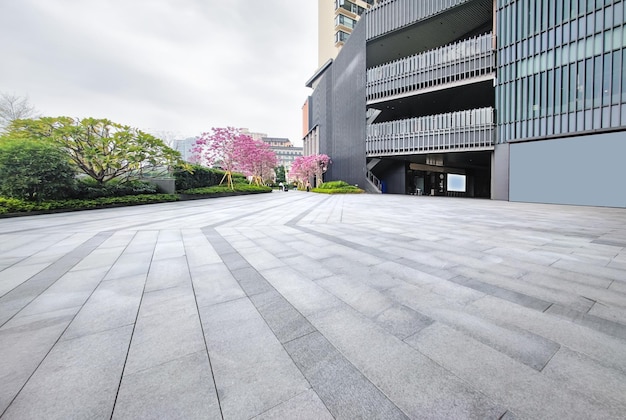 Leere Backsteinplätze und moderne Gebäude in Stadtparks mit grünem Baumhintergrund