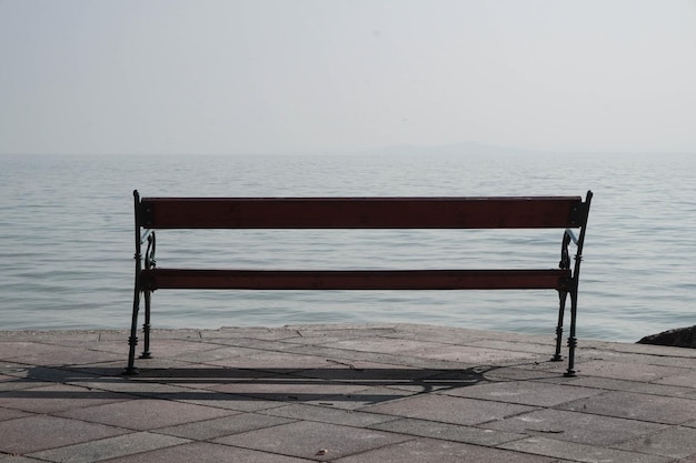 Foto leere bank am meer gegen den himmel