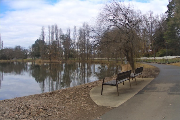 Leere Bank am See gegen den Himmel