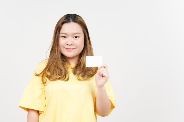 Leere Bankkarte oder Kreditkarte der schönen asiatischen Frau halten, die gelbes T-Shirt trägt