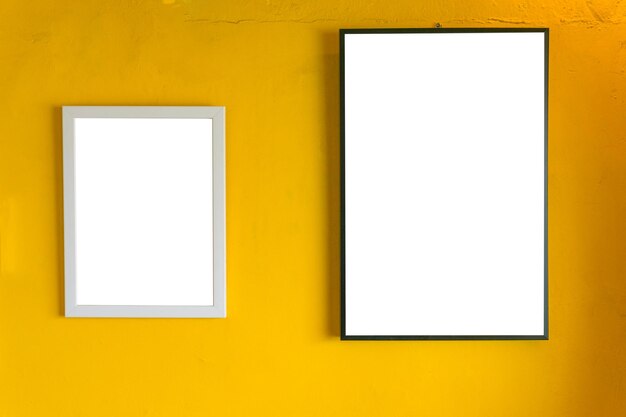 Leere Bilderrahmen gegen eine gelbe Wand