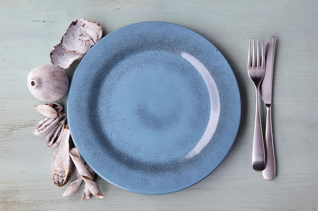 Leere blaue Platte und exotische Gewürze und Früchte auf hellblauem Holztisch. ÃƒÂ Ã‚Âœockup zum Anzeigen eines Gerichts. Flach legen