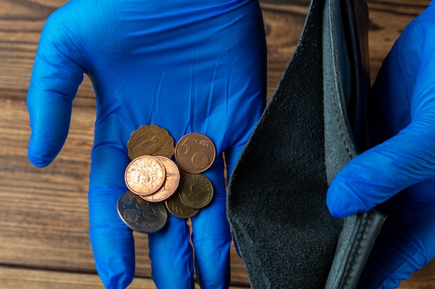 Leere Brieftasche und Hand mit wenigen Münzen