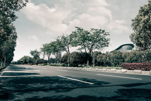 Leere gekrümmte Straße, blauer Himmel und Wolke