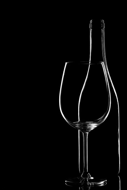 Leere Glasflasche mit isoliertem Glas auf schwarzem Hintergrund Copyspace