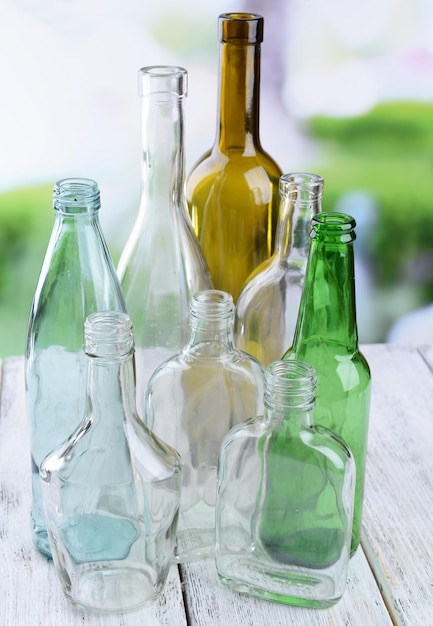 Foto leere glasflaschen auf dem tisch auf hellem hintergrund