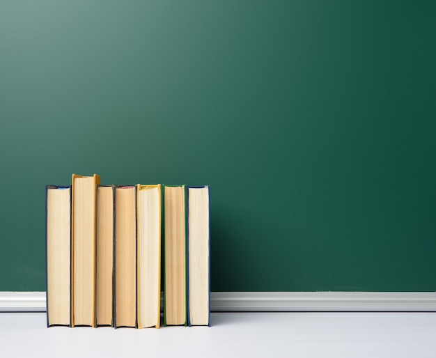 Leere grüne Kreide Schulbehörde und Stapel Bücher, zurück zur Schule