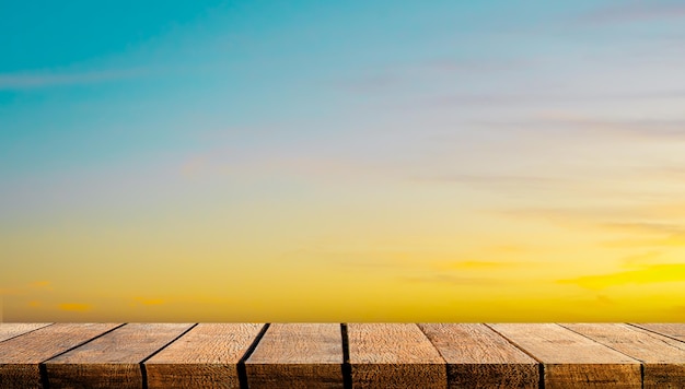 Leere Holzbrettregal-Tischtheke mit Kopienraum für Werbehintergrund und Hintergrund mit orangefarbenem Sonnenuntergangshimmel.