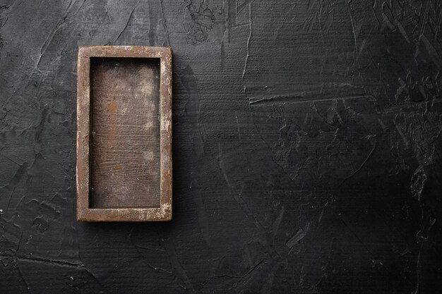 Leere Holzkiste mit Kopierraum für Text oder Lebensmittel, Draufsicht flach liegend, auf schwarzem, dunklem Steintischhintergrund