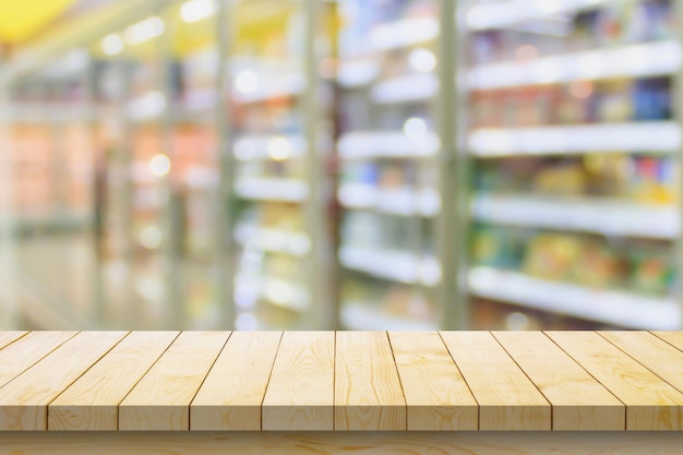 Leere Holztischplatte mit verschwommenem Hintergrund aus einem Supermarkt für die Produktdarstellung