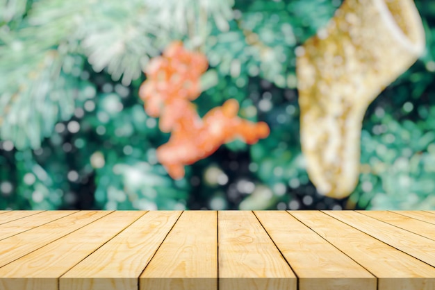 Leere Holztischplatte mit verschwommenem Weihnachtsbaum mit hellem Bokeh-Hintergrund