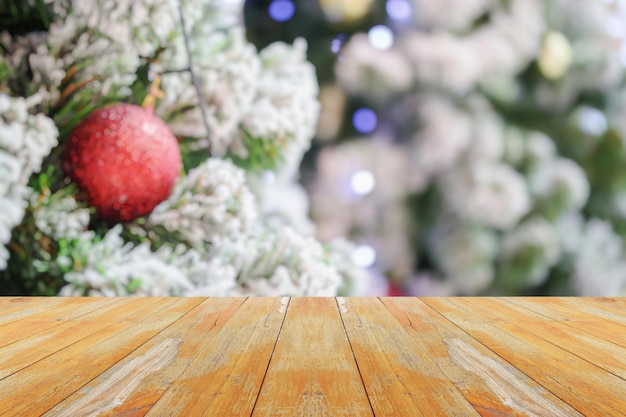 Leere Holztischplatte mit verschwommenem Weihnachtsbaum mit hellem Bokeh-Hintergrund