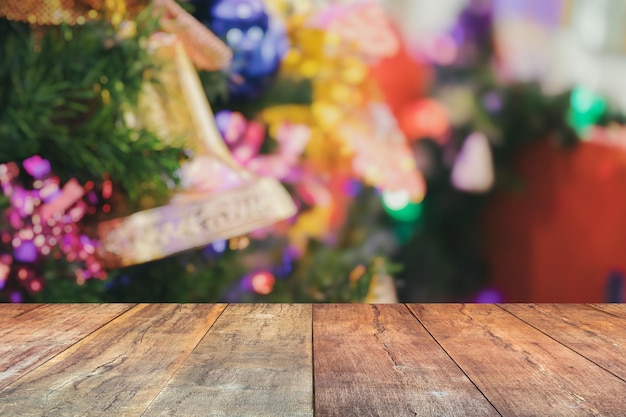 Leere Holztischplatte mit verschwommenem Weihnachtsbaum mit hellem Bokeh-Hintergrund