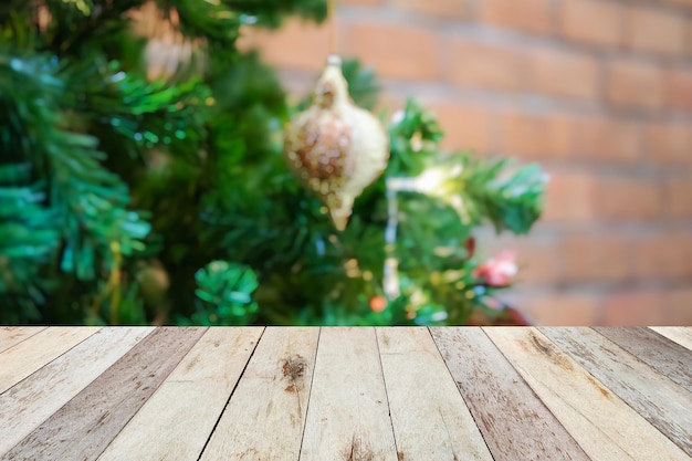 Leere Holztischplatte mit verschwommenem Weihnachtsbaum mit hellem Bokeh-Hintergrund