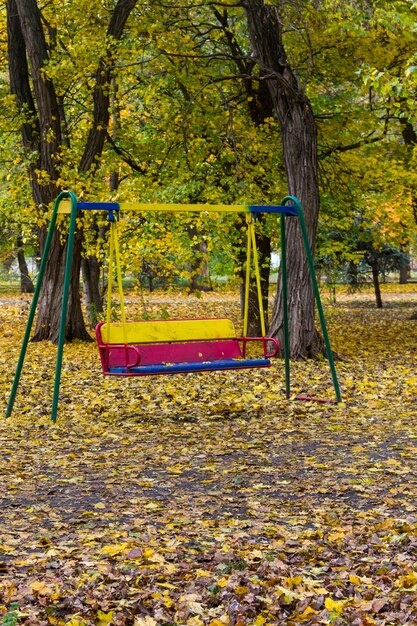 Leere Kinderschaukel im Stadtpark im Herbst