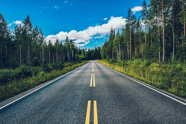 Leere Landstraße durch Wälder im Sommer Finnland