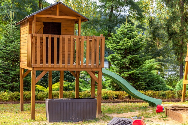 Leere moderne hölzerne Kinderspielplatz gesetzt auf grünem Hof im öffentlichen Park im Sommertag.