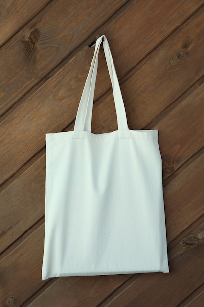 Leere Öko-Tasche auf hölzernem Hintergrund, Platz für Text
