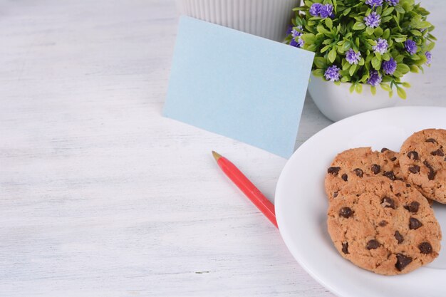 Leere Papierkarte mit rotem Stift und Keksen