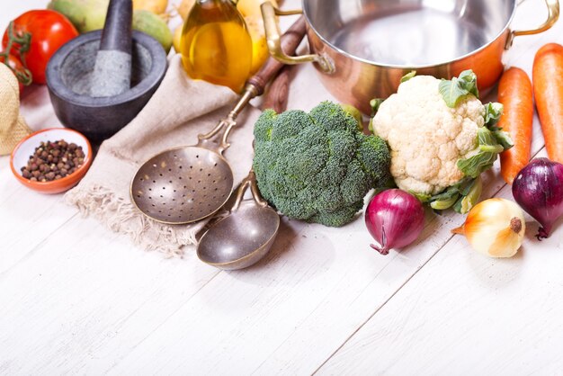 Leere Pfanne mit verschiedenen Produkten zum Kochen auf Holztisch, Draufsicht mit Kopierraum