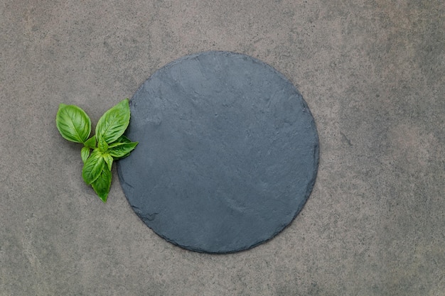 Leere Pizzaplatte für hausgemachtes Backen auf dunklem Beton Lebensmittelrezeptkonzept auf dunkler Steinhintergrundtextur mit Kopierraum