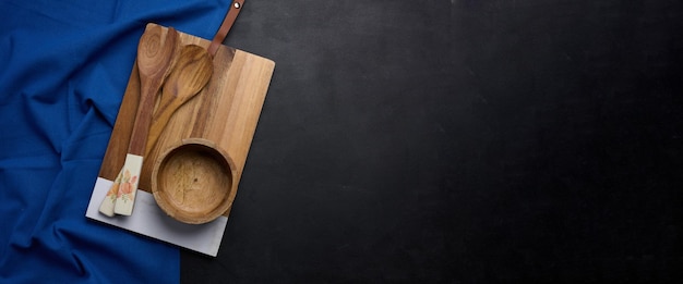 Leere rechteckige hölzerne Küchen-Schneidbrette leere Schüssel und hülle Löffel auf schwarzer Tischplatte