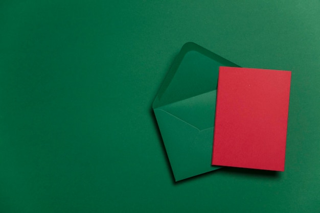 Leere rote karte mit grünem papierumschlag weihnachtskartenvorlage mock up