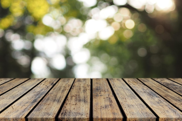 Leere rustikale Plank-Holz-Tischplatte mit blauem Baum-Bokeh-Hintergrund