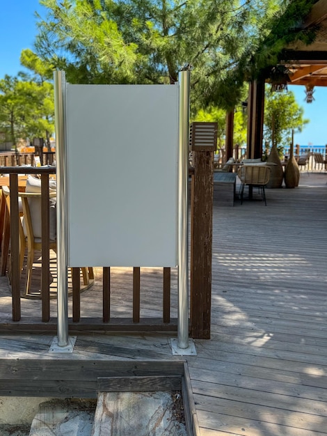 Leere Schilder in einem friedlichen Outdoor-Esszimmer am Ufer unter klarem blauen Himmel