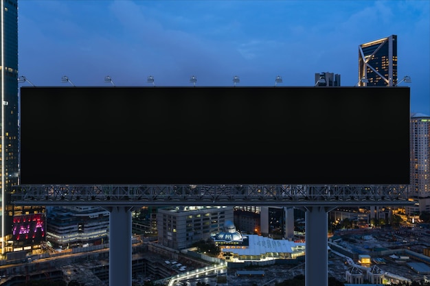 Foto leere schwarze straßenwerbetafel mit kuala lumpur-stadtbild-hintergrund bei nacht. straßenwerbeplakat-attrappe, 3d-rendering, vorderansicht. konzept des marketings zur förderung oder zum verkauf von ideen oder produkten