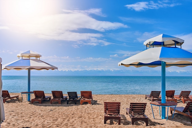 Leere Sonnenliegen am Strand. Stühle am Strand neben dem Hotel während der Ferien.