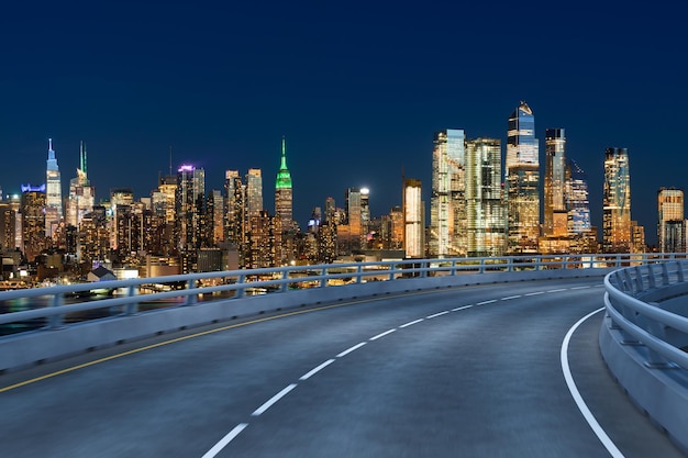 Leere städtische Asphaltstraße außen mit Stadtgebäuden Hintergrund Neue moderne Autobahn Betonbau Konzept des Weges zum Erfolg Transportlogistikbranche schnelle Lieferung New York USA