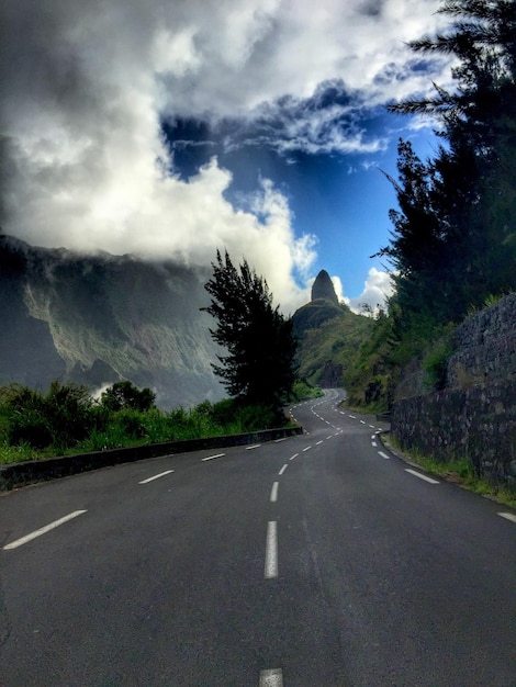 Leere Straße durch die Berge gegen einen bewölkten Himmel