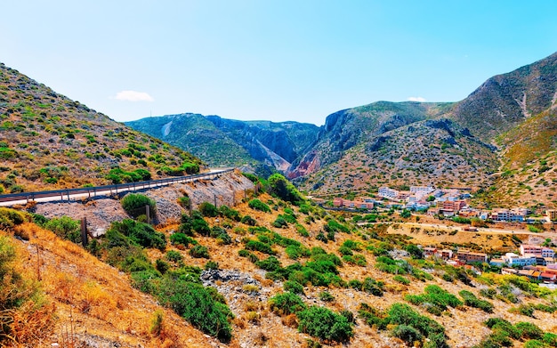 Leere Straße ohne Autos von Buggerru auf der Insel Sardinien im italienischen Sommer. Transport auf der Autobahn Europas. Urlaub auf der Autobahn. Provinz Cagliari. Berge im Hintergrund. Gemischte Medien.