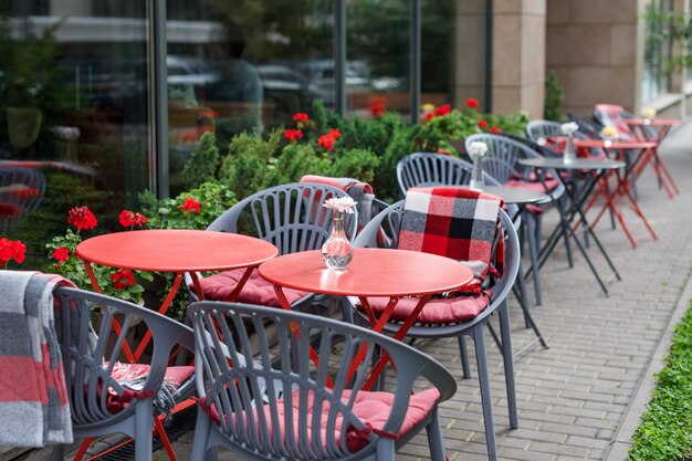 Leere Stühle im Straßencafé oder Restaurant rote und graue metallische Tische und Stühle Straßencafé