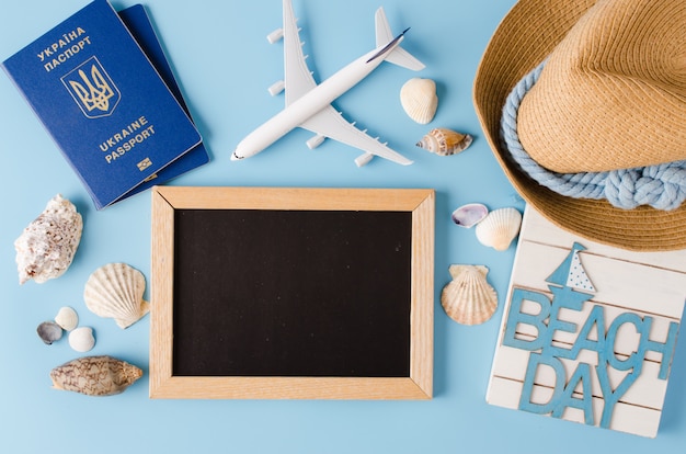 Leere Tafel mit dekorativem Flugzeug, Pässen und Muscheln. Sommerreisekonzept.