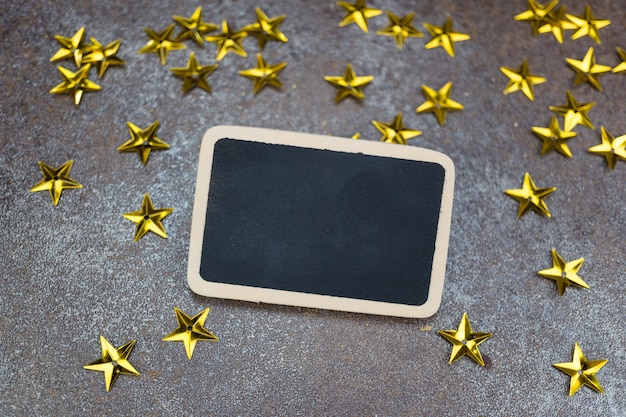 Leere Tafel mit goldenen Sternen auf rustikalem Fliesenhintergrund