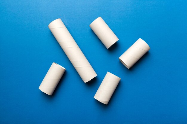 Leere Toilettenpapierrolle auf farbigem Hintergrund Recycelbare Papierröhre mit Metallsteckende aus Kraftpapier oder Pappe