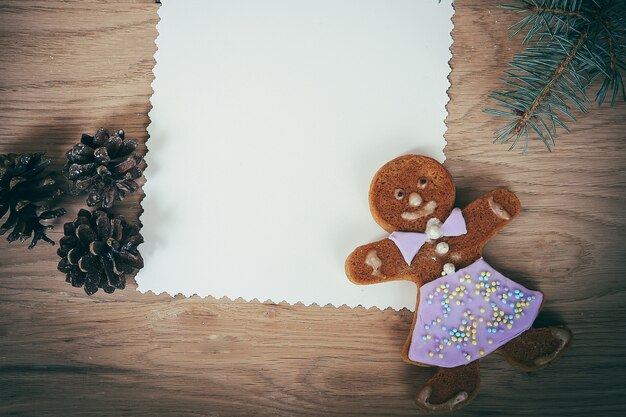 Leere Weihnachtskarte, Lebkuchen und Bleistift auf Holzuntergrund. Platz für Text